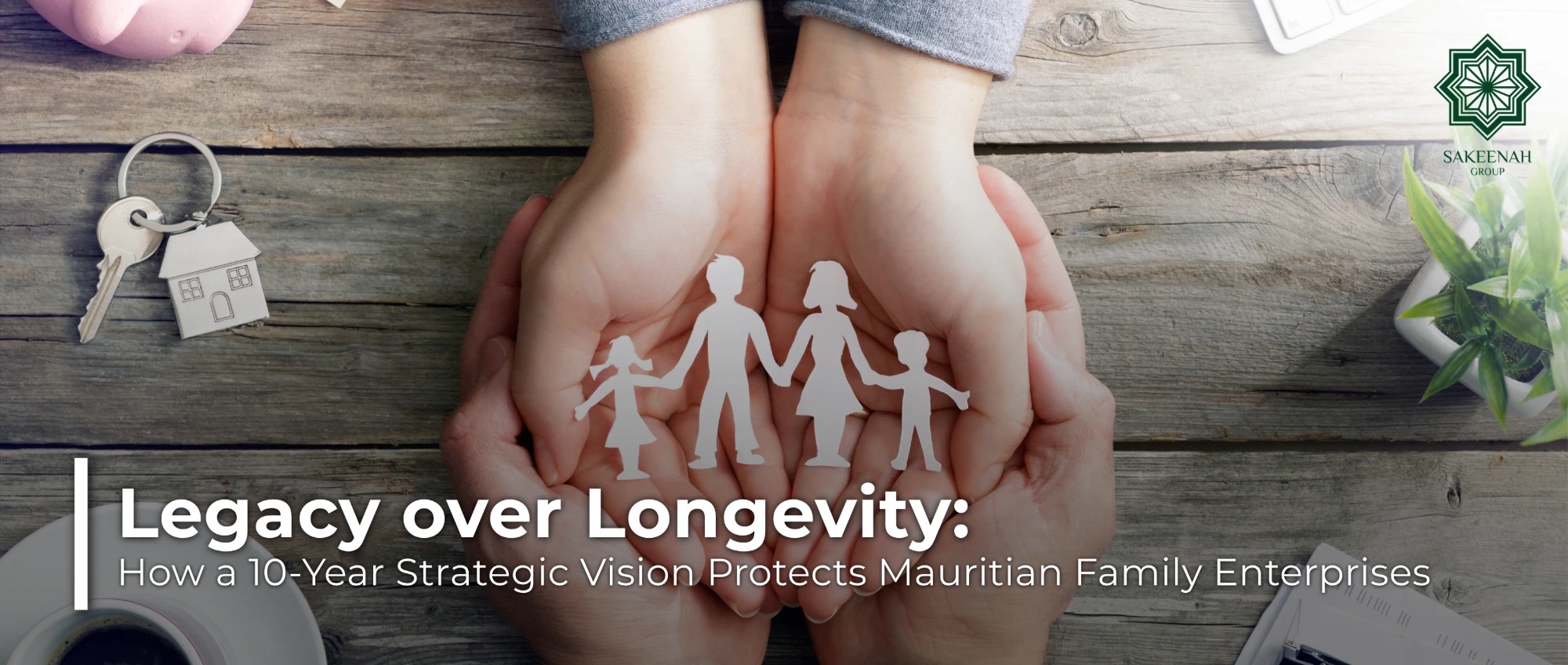 Hands cupping a paper cutout of a family on a wooden surface next to house keys, representing family protection, asset security, and generational legacy. The image features the Sakeenah Group logo in the top-right corner and text reading: 'Legacy over Longevity: How a 10-Year Strategic Vision Protects Mauritian Family Enterprises.'